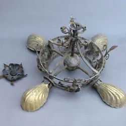 The corroded chandelier frame with its shell-shaped shades removed